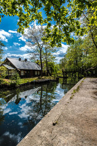 Reflection of trees and building in lake against sky