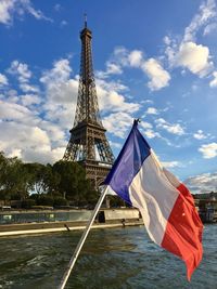 French flag by eiffel tower over river