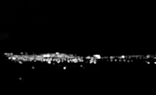 Close-up of illuminated lights over black background