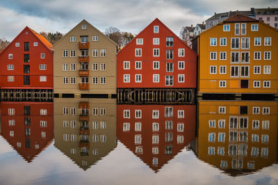 Reflection of houses in city against sky