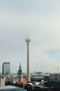 Tower in city against sky