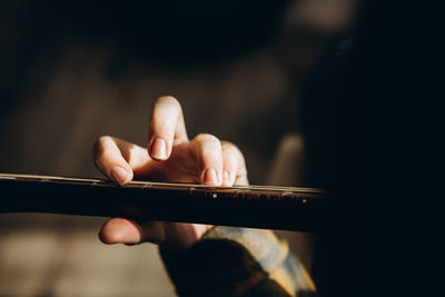 Fingers grip the strings of the guitar. teenage girl learning to play the girat