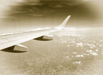 Airplane flying over water against sky