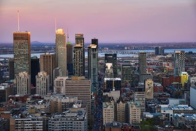 Aerial view of city buildings against sky during sunset