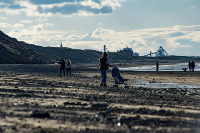 People on beach against sky
