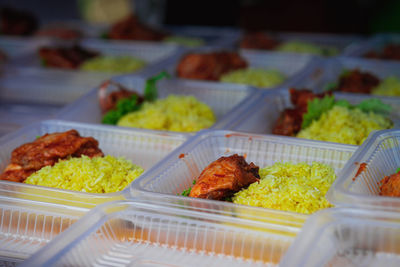 Typical malaysian daily food at street stall or bazaar called nasi ayam tomato packed in container .