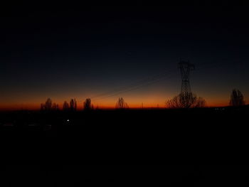 Silhouette of trees against sky at night