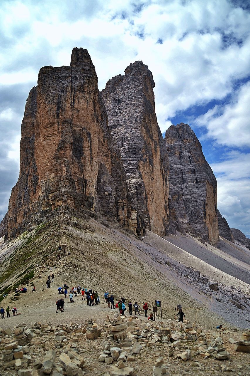 rock, sky, cloud, group of people, travel destinations, travel, nature, rock formation, scenics - nature, land, mountain, environment, landscape, leisure activity, large group of people, beauty in nature, geology, tourism, crowd, non-urban scene, tourist, lifestyles, hiking, physical geography, outdoors, vacation, mountain range, activity, trip, day, holiday, plateau, men, cliff, formation, terrain, architecture, desert, walking, adult, valley, extreme terrain