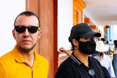 Portrait of young man wearing sunglasses standing outdoors