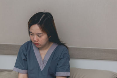 Portrait of young woman sitting on sofa at home