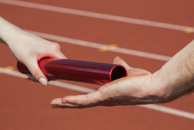 Cropped hand of man passing relay baton to partner