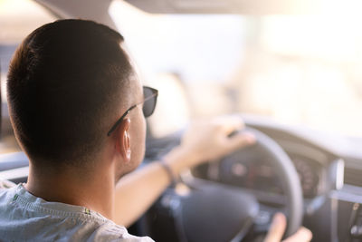 Rear view of man driving car