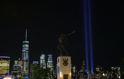 Statue in city at night