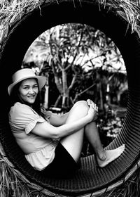 Portrait of smiling young woman sitting in hat