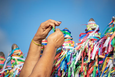 Cropped hand of woman holding souvenir ribbons