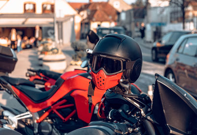 Black and red helmet on motorcycle parked in street in city