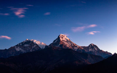 Scenic view of snowcapped mountains against blue sky