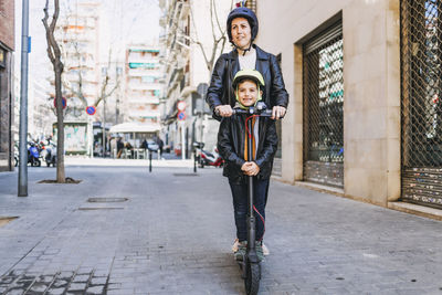 Mother and son riding on electric scooter in city