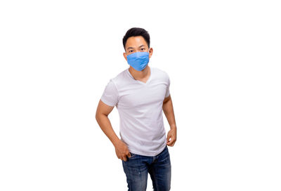 Portrait of young man standing against white background