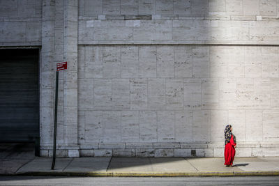 Full length of woman on sidewalk against building in city