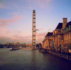 Tower bridge in front of river against sky in city