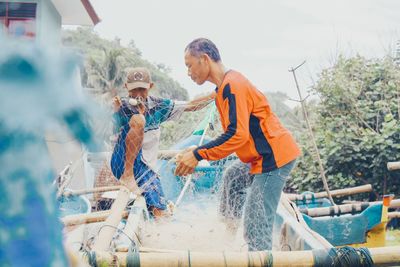 Rear view of people working in water