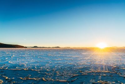 Scenic view of frozen sea against sky during sunset