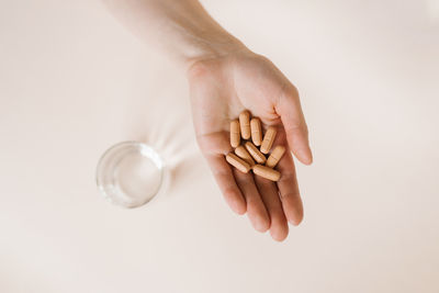 Cropped hand of woman holding fidget spinner against white background