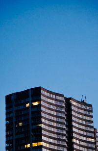 Low angle view of modern building against clear blue sky