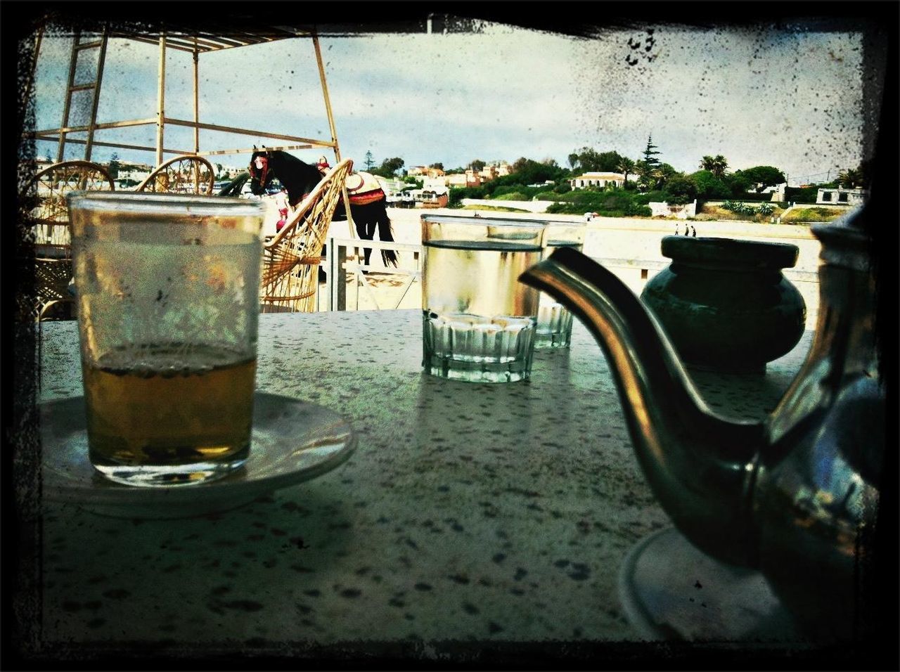 drink, table, transfer print, refreshment, food and drink, water, indoors, auto post production filter, drinking glass, freshness, still life, glass - material, close-up, day, chair, sunlight, restaurant, potted plant, glass, coffee cup