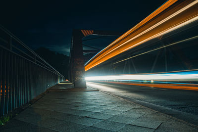 Light trails on bridge in city at night