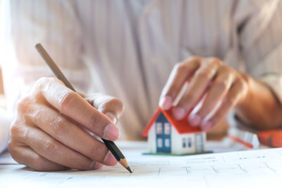 Close-up of man holding paper with text on table