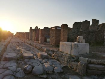 Stone wall against clear sky during sunset