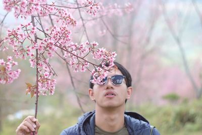 Man wearing sunglasses and flower tree