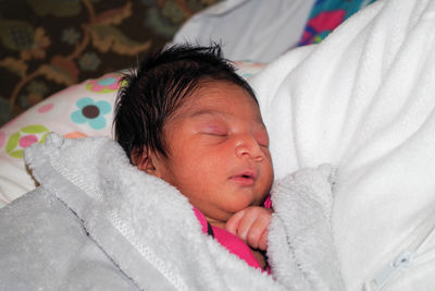 High angle view of baby sleeping on bed