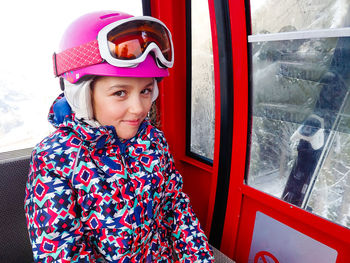 Portrait of smiling girl sitting in overhead cable car