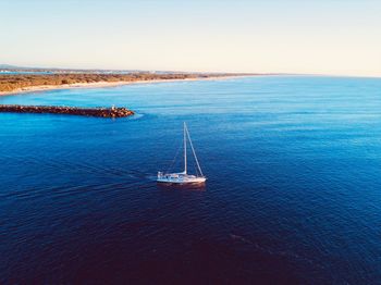 Sailboat sailing in sea against sky