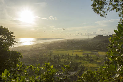 Scenic view of landscape against bright sun