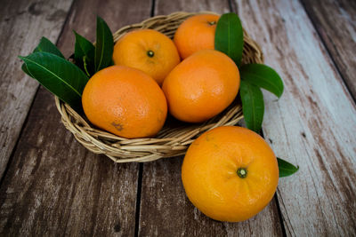 High angle view of orange fruits in basket on table