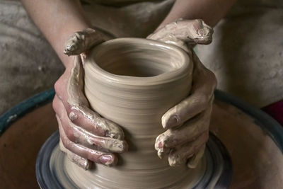 Creating a jar or vase of white clay close-up. master crock. man hands making clay jug macro. 