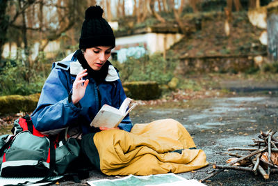 Full length of man sitting in park during winter