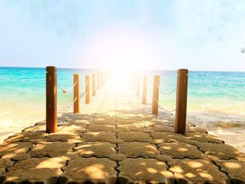 Wooden posts on beach against sky