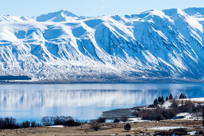 Scenic view of lake and mountains against blue sky