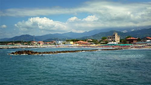 Scenic view of sea by city against sky