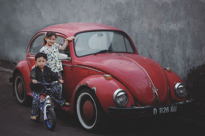 Siblings by vintage car