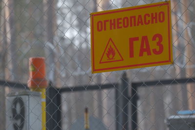 Close-up of information sign on fence