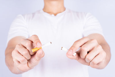 Close-up of person holding hands over white background