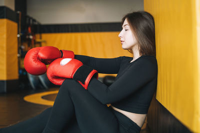 Young brunette woman in black wear engaged boxing training in the fitness club gym