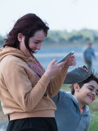 Side view of young woman using mobile phone