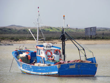 Boat moored on river against sky